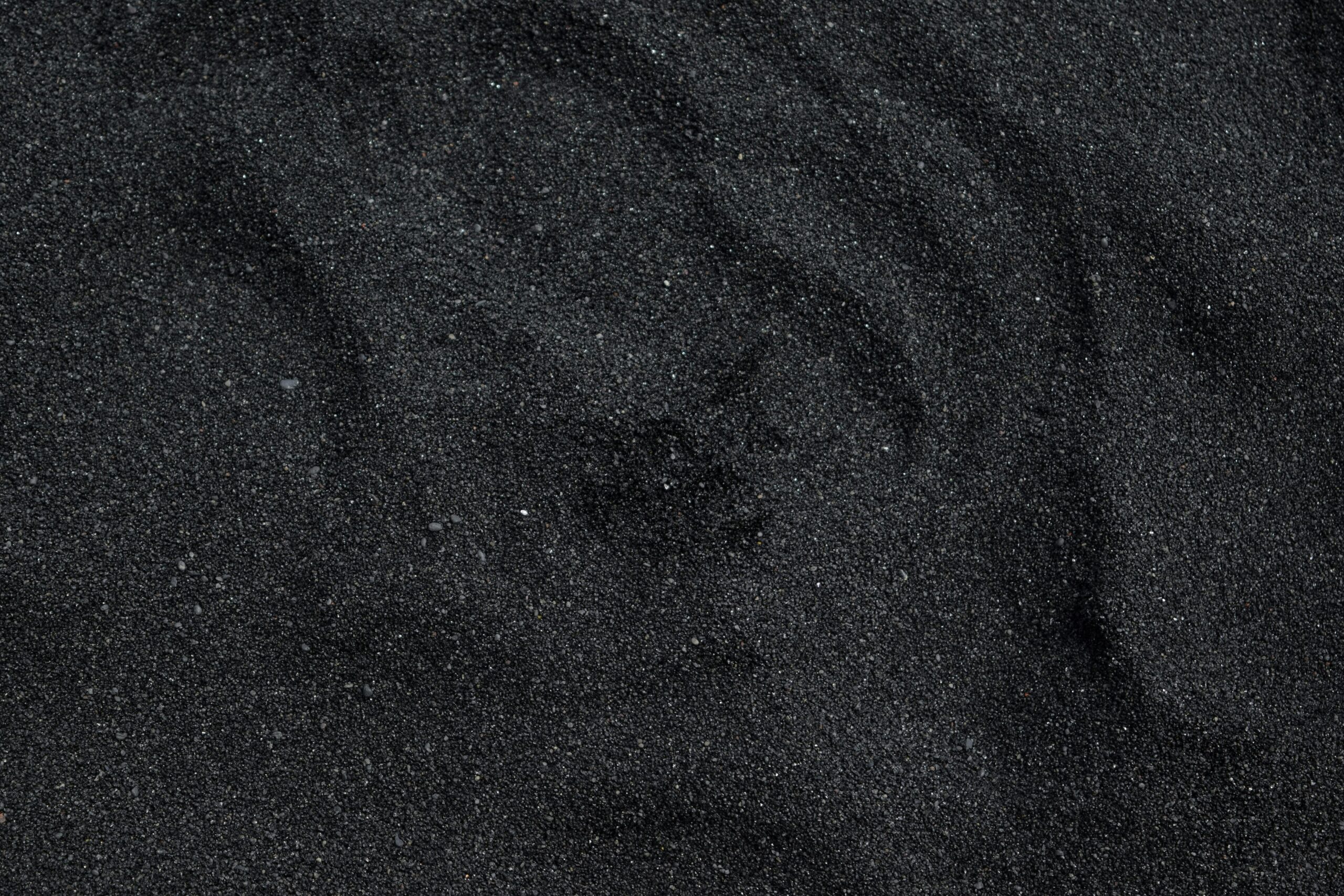 Close-up of black sand texture from Waimea Beach in Hawaii. Ideal for backgrounds.